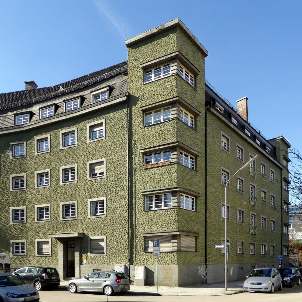Mehrstöckiges grünes Eckhaus in München.
